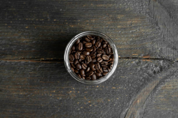 fresh arabica coffee beans in a little jar on a wooden table. fresh coffee beans. - coffee cup bean sugar imagens e fotografias de stock