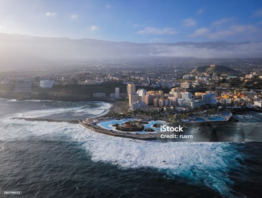 Aerial panorama of Puerto de la Cruz resorts and pools surrounded by sea waves, Tenerife, Canary islands, Spain. Aerial view of Puerto de la Cruz, Tenerife Aerial View Stock Photo