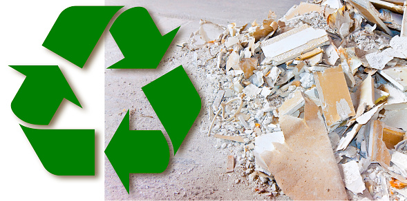 Recovery and recycling of special waste plasterboard for the production of new gypsum products - concept with a demolished plasterboard wall made of gypsum and cardboard.