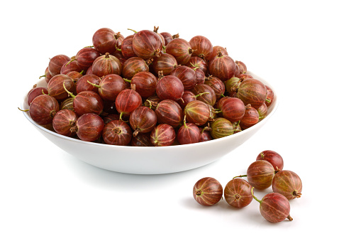 ripe gooseberries in a plate close-up on a white background, horizontal view