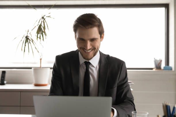 istock Smiling businessman work online on computer in office 1307791718