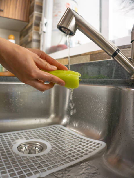istock woman washing vegetables, yellow pepper on kitchen 1307793105