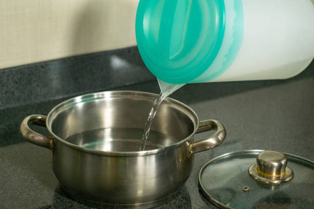 istock pouring water from jug in cooking pot 1307793115