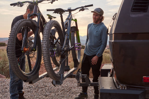 Nothing can stop us once we have an adventure planned Shot of two mountain bikers unloading their gear bicycle rack photos stock pictures, royalty-free photos & images