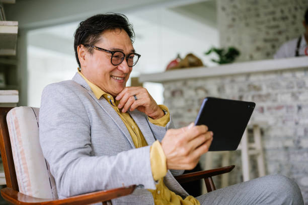 istock Happy Asian mature business man using digital tablet in cafe 1307797679