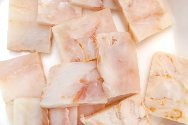 istock A fresh cod fish fillet cut into squares lying on a white plate, top view. 1307797727