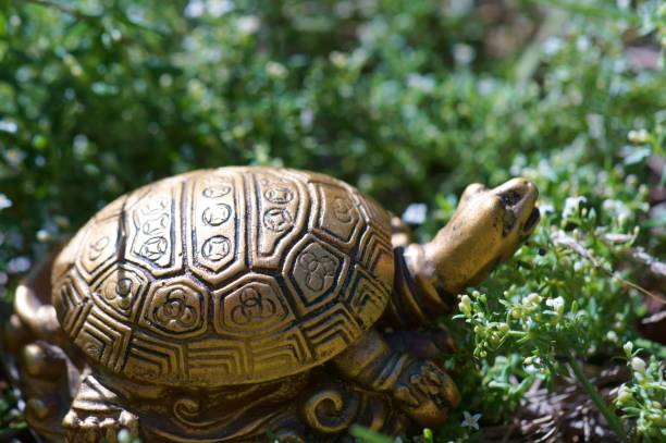 istock Metal turtle in the green grass. 1307799845