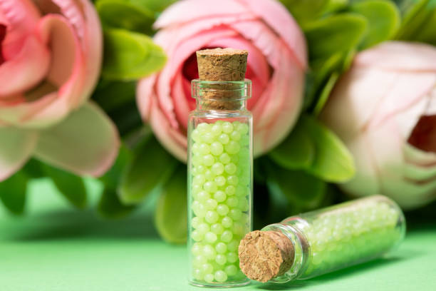 glass bottles with green granules with roses. homeopathic remedies