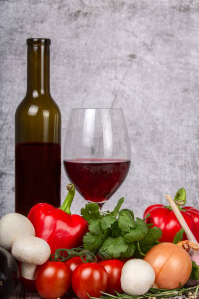 istock wine in group of ripe vegetables on grey background 1307805910