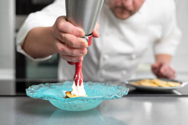 chef professionista che tiene in mano un sifone di schiuma in una cucina del ristorante. foto di alta qualità - siphon foto e immagini stock