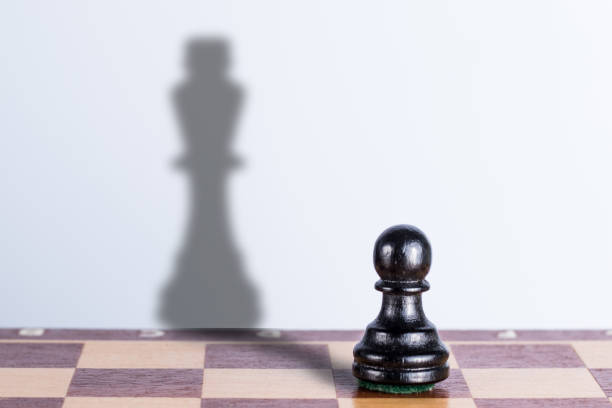 istock Black chess pawn with king shadow. Hidden opportunities concept 1307809184