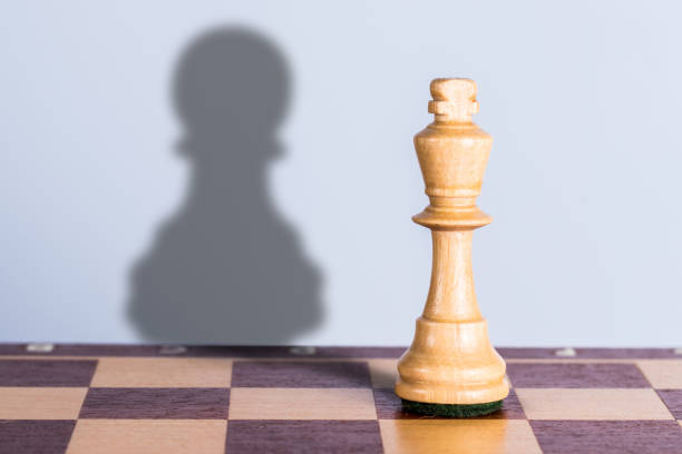 istock White chess king with pawn shadow. Exaggeration of possibilities concept. 1307809206