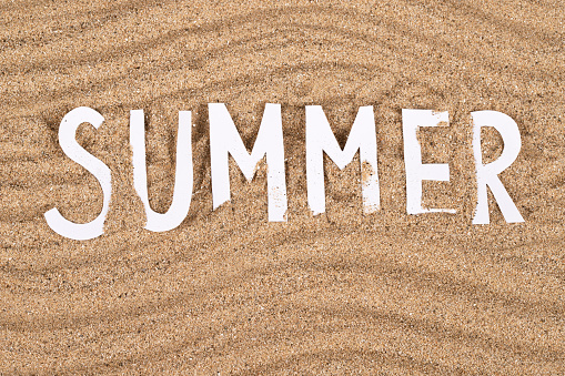 Summer word  on a beach sand background