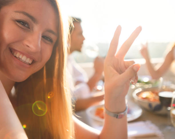 istock Happy woman looking at the camera making a peace sign. 1307814715