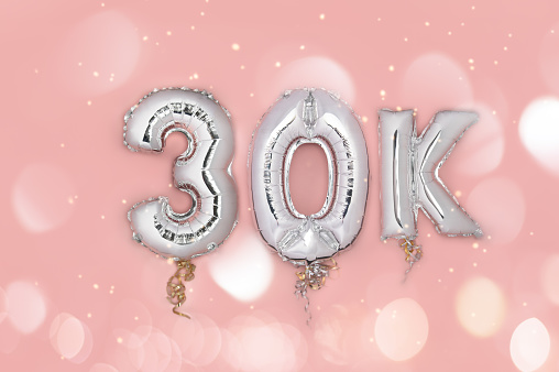 Silver Number Balloons 30K, meaning thirty thousand, on pink background. Holiday Party Decoration, 30k followers or likes, social media or postcard concept with top view