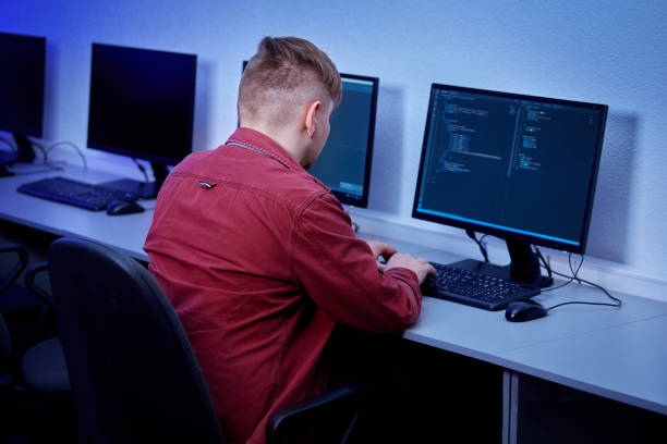 istock A dark-haired male programmer works in the office late at night alone. 1307816105