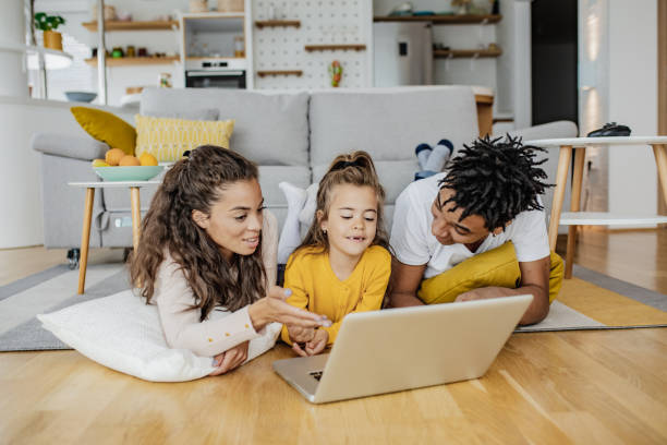istock Parents and their daughter are using laptop at home 1307818505