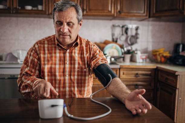 senior man som mäter blodtrycket - blodtryck orolig bildbanksfoton och bilder
