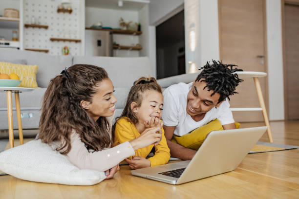 istock Parents and their daughter are using laptop at home 1307818514