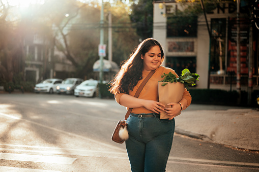 Woman crossing street holding shopping bag