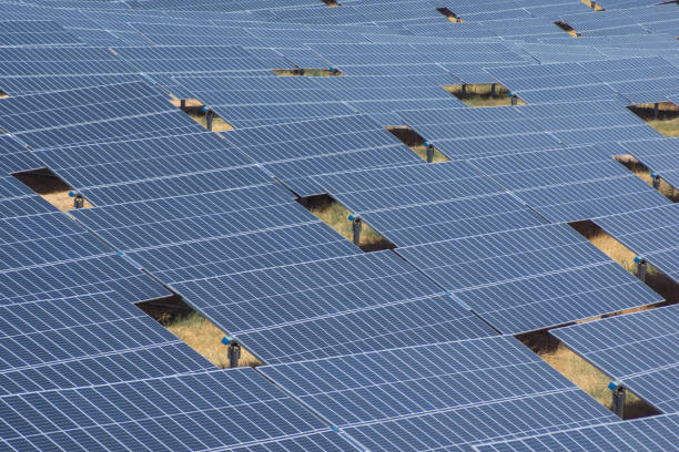 istock solar panels on a summer day filling almost the entire image except for some gaps through which the terrain can be seen 1307828485