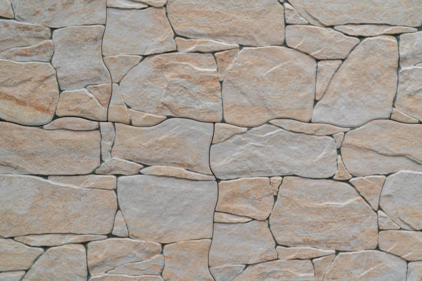 istock Background of a wall made with different-sized gray and orange stones 1307829370