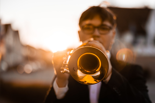 Trumpet player playing jazz musician. Woman playing trumpet brass instrument isolated on black