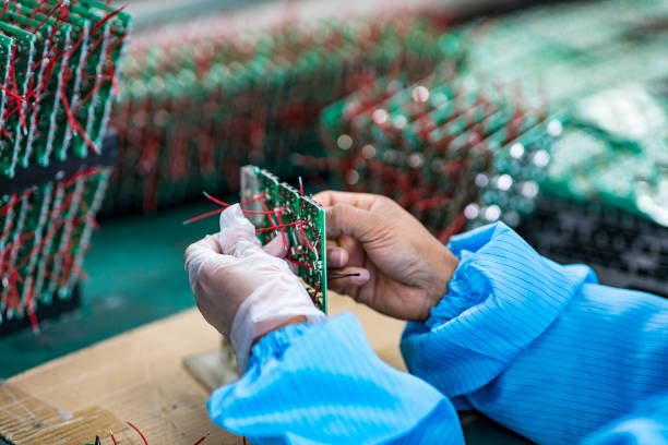 il lavoratore sta lavorando sulla catena di montaggio - service electronics industry circuit board capacitor foto e immagini stock