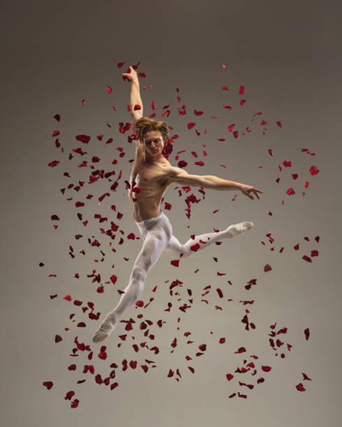 istock Young and graceful ballet dancer on studio background with rose petals. Art, motion, action, flexibility, inspiration concept. 1307840539
