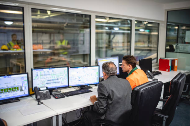 istock Manager and Worker Monitoring Computers at Waste Facility 1307840847