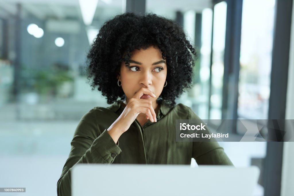You can take a fall and still find a way Shot of a young businesswoman looking thoughtful while using a laptop in a modern office Contemplation Stock Photo