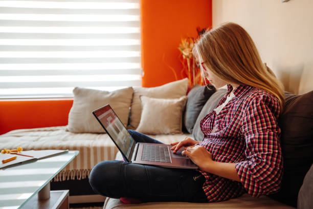 istock Beautiful schoolgirl using laptop at home 1307843440