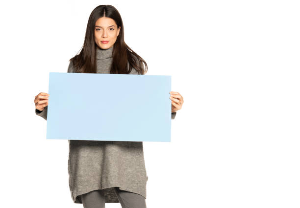 istock young beautiful woman holding a blue empty board on white 1307843578