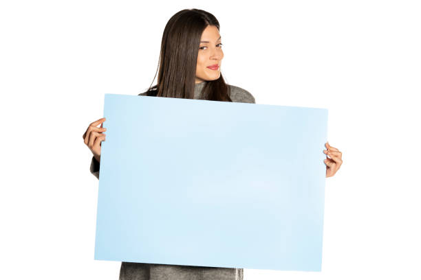 istock young beautiful happy woman holding a blue empty board on white background 1307843593
