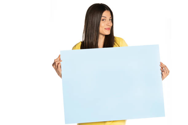 istock young beautiful happy woman holding a blue empty board on white background 1307843621