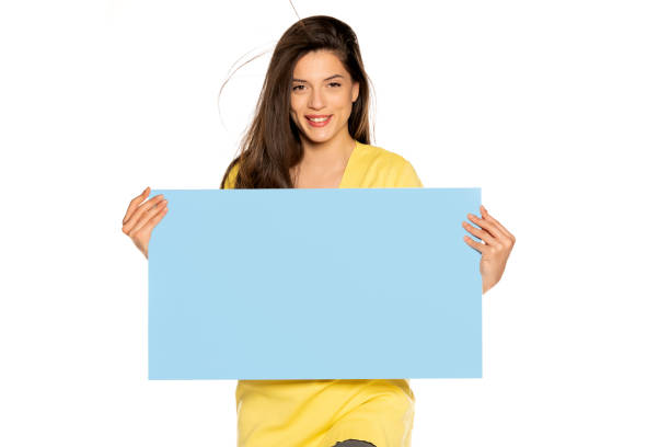 istock young beautiful happy woman holding a blue empty board 1307843639