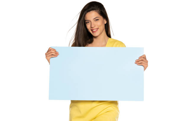 istock young beautiful happy woman holding a blue empty board on white background 1307843643