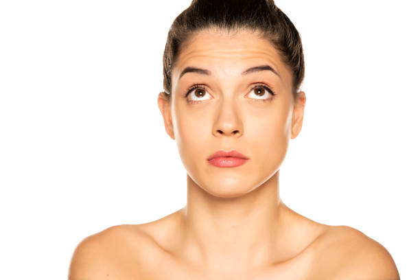 istock Young beautiful woman looking up on white background 1307843896