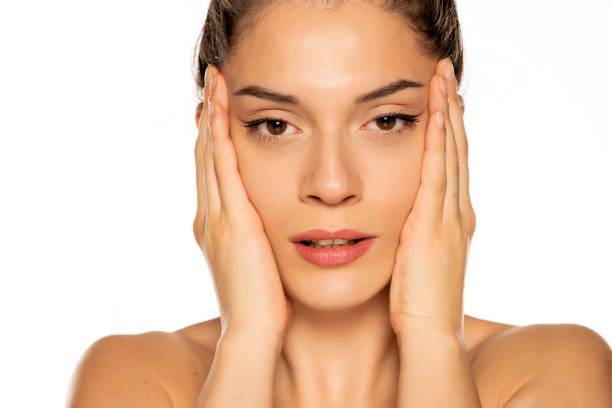 istock a young beautiful woman tightens her face with her hands 1307843918