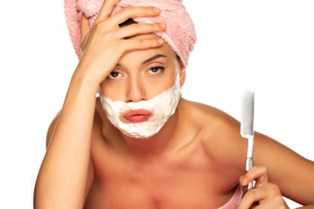 Young disappointed woman shaves her face