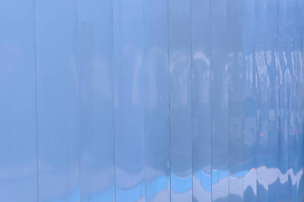 Blue tinted image of white metal construction site wall panels with shallow depth of field.