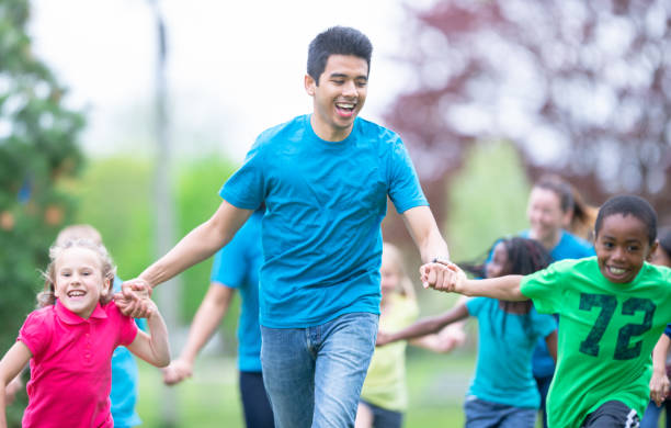 istock Camp Counselor Running With Children at a Summer Camp 1307852289