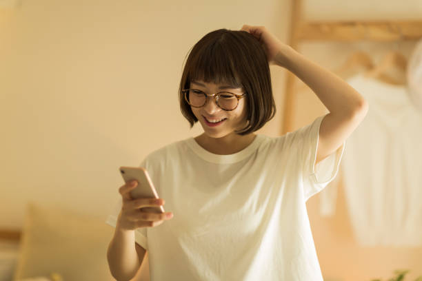 自宅で過ごす若い女性 - スマホ 日本人 ストックフォトと画像