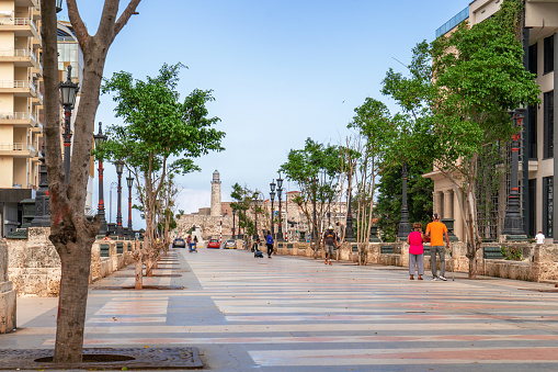 Havana Cuba. November 25, 2020: Paseo del Prado in Havana with trees and benches on its sides, in the background is the Morro lighthouse, places very popular with Cubans and tourists