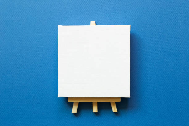 istock Easel with blank canvas on blue background. top view, copy space 1307856187