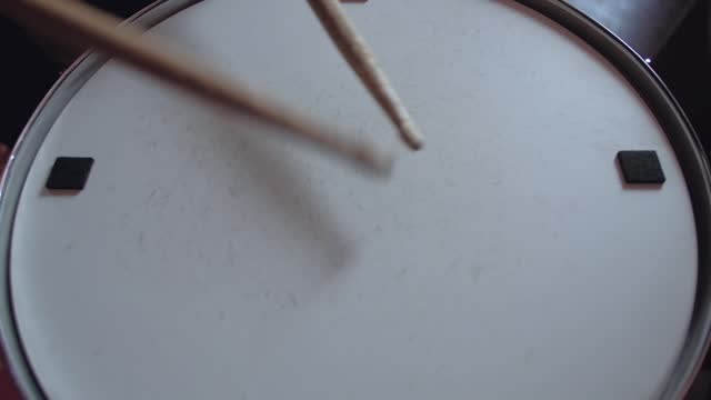 drummer plays with sticks on a snare drum