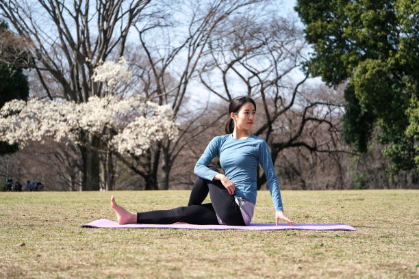 istock Yoga instructor stretching at public park in early Springtime 1307863060