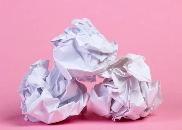 istock Crumpled paper balls on pink pastel background 1307864311