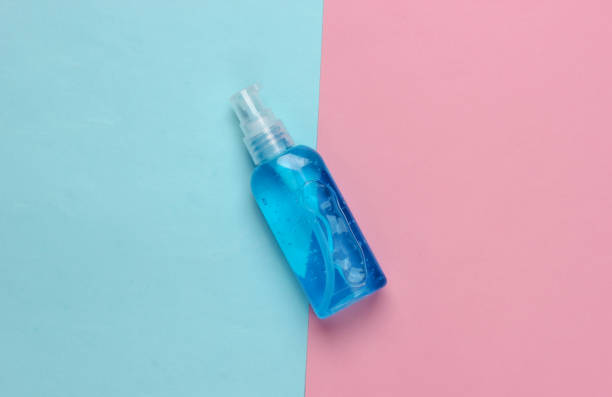 istock Antiseptic bottle on a blue-pink background. Disinfectant. Top view 1307865439