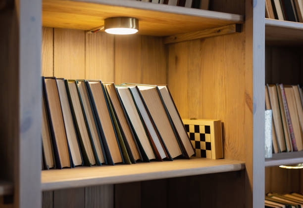istock shelf with books in the bookcase lit by a lamp 1307865628